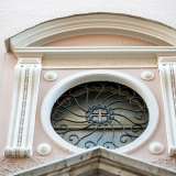 Al centro della facciata � presente un rosone tra volute scanalate con sovrastante timpano curvilineo